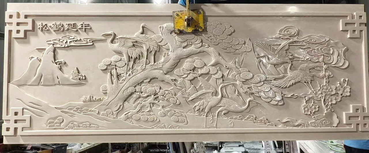 Detailed carved stone relief panel in a fabrication workshop