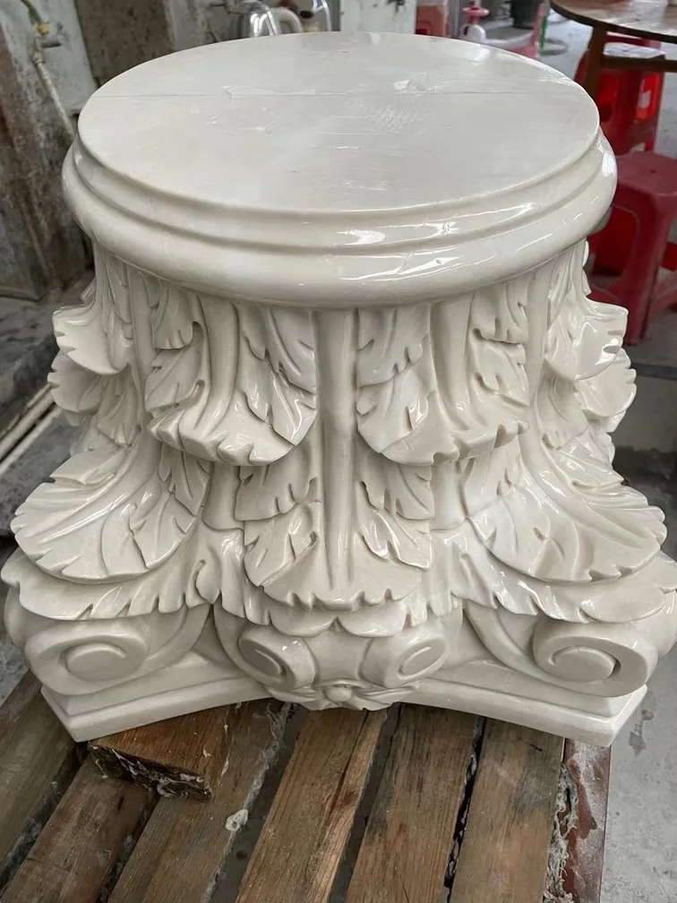 Intricately carved stone column capital in a workshop